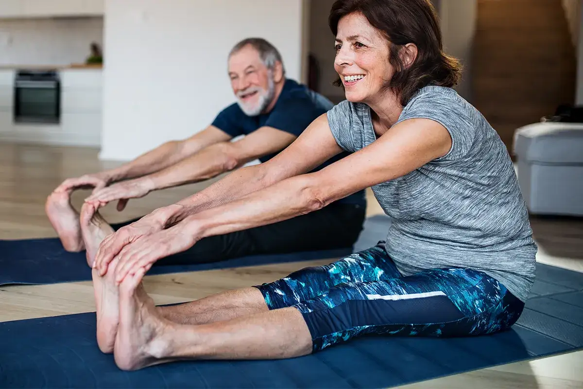 4 Weil das Ekzem an meinem trockenen Unterschenkel sich rasch bessert Zwei ältere Personen dehnen sich auf Sportmatten