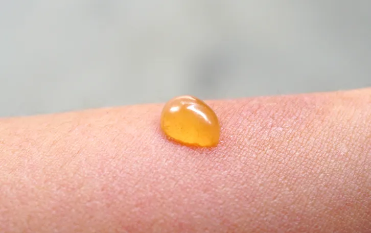 Ein gelber Tropfen auf einer Hautpartie